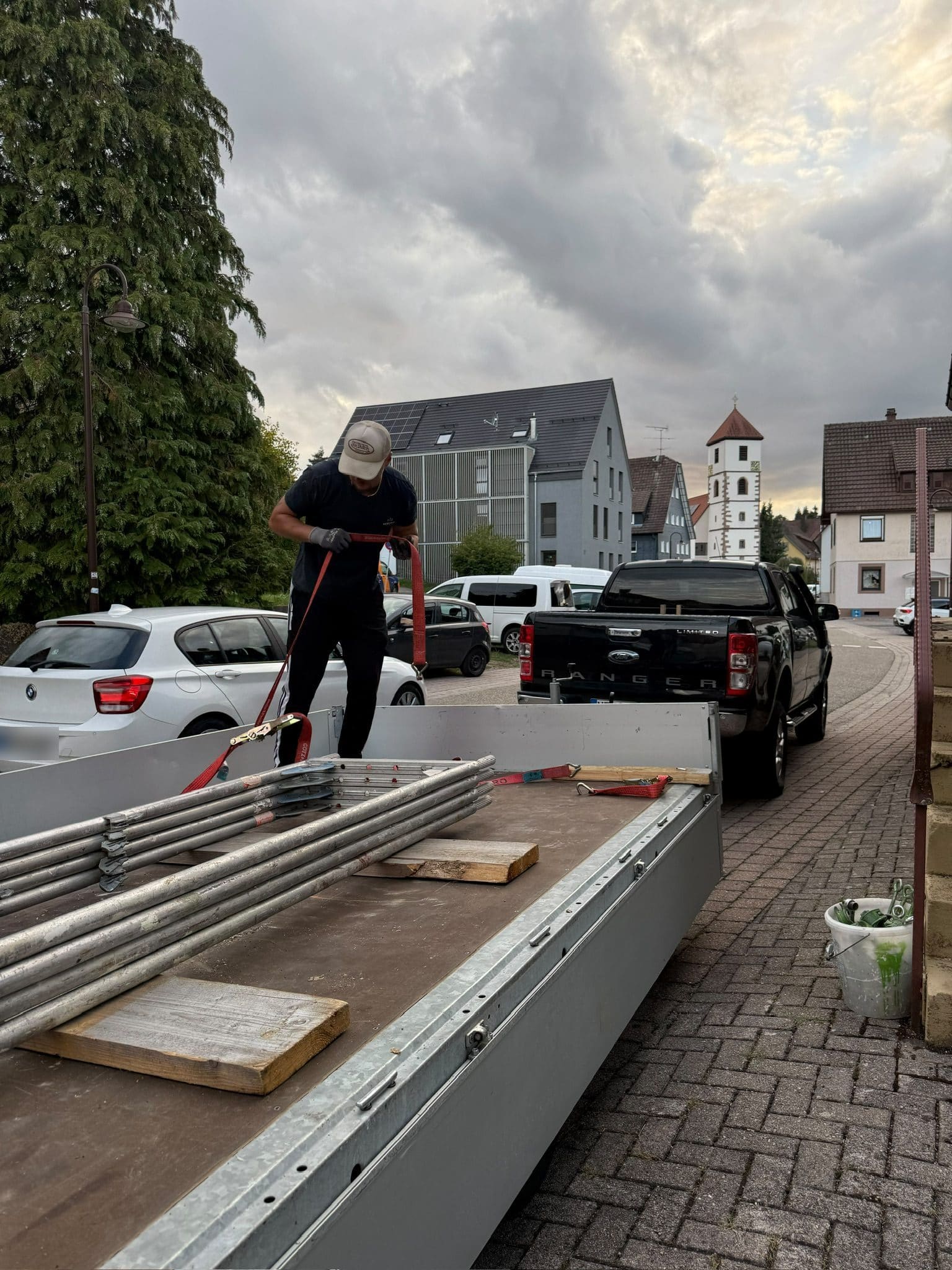 Gerüstmaterial wird vor Ort vom Anhänger abgeladen